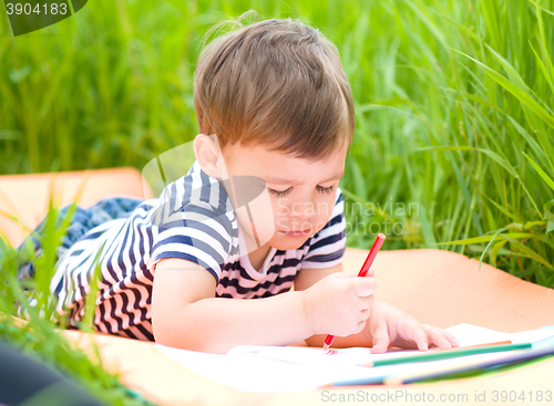 Image of Little boy is playing with pencils