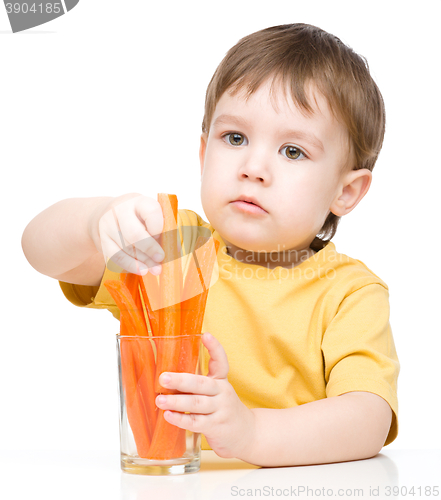 Image of Little boy is eating carrot