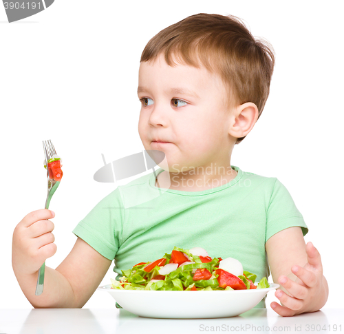 Image of Cute little boy is eating vegetable salad