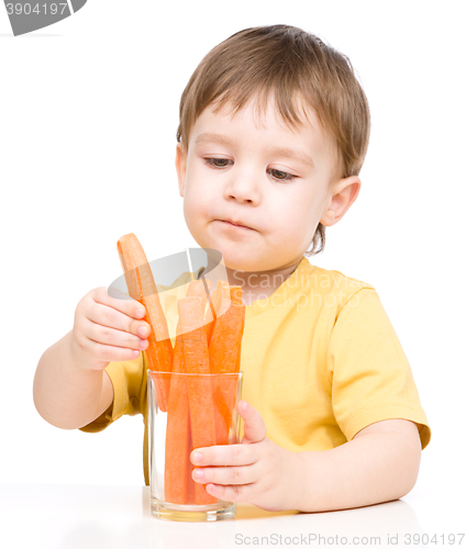 Image of Little boy is eating carrot