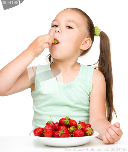 Image of Little girl is eating strawberries