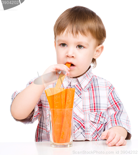 Image of Little boy is eating carrot