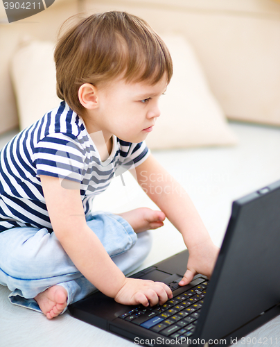 Image of Little boy is playing on laptop