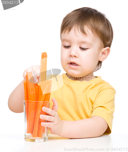 Image of Little boy is eating carrot