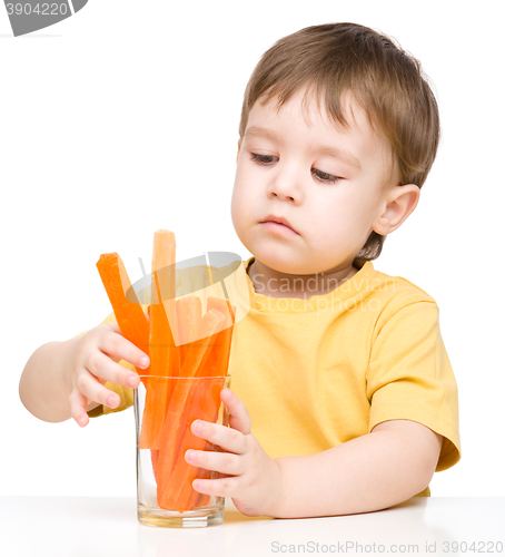 Image of Little boy is eating carrot