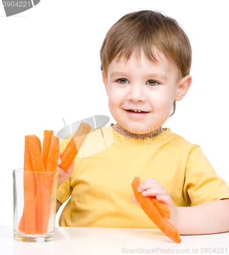 Image of Little boy is eating carrot