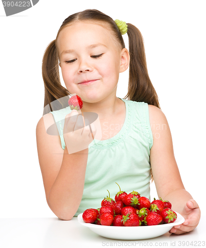 Image of Little girl is eating strawberries