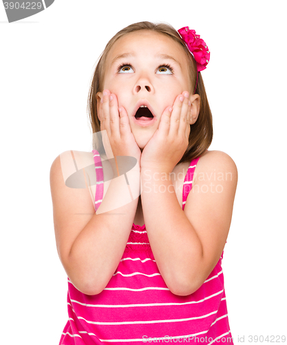 Image of Little girl is holding her face in astonishment