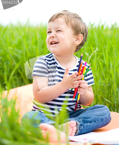 Image of Little boy is playing with pencils