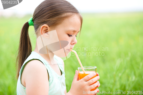 Image of Little girl is drinking orange juice