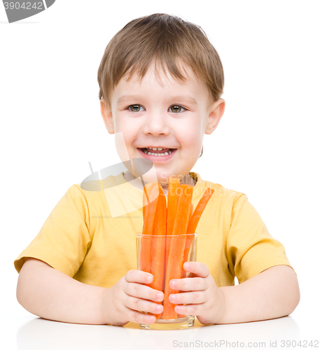 Image of Little boy is eating carrot
