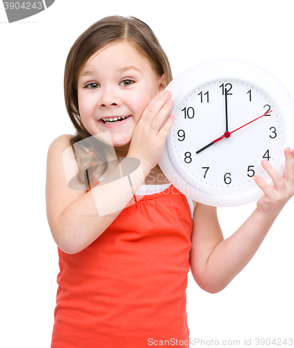 Image of Little girl is holding big clock