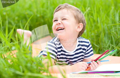 Image of Little boy is playing with pencils