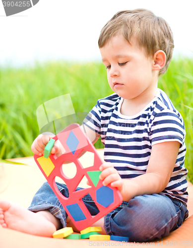 Image of Little boy is playing with toys