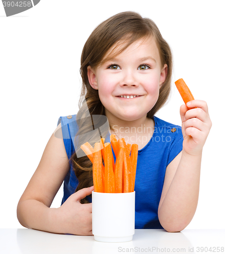 Image of Cute little girl is eating carrot