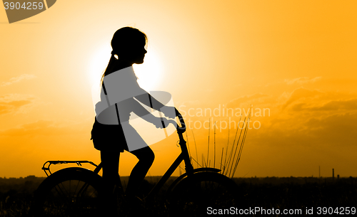 Image of Silhouette of little girl on a bicycle