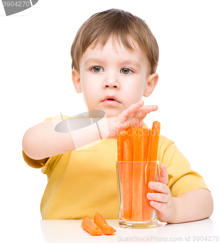 Image of Little boy is eating carrot