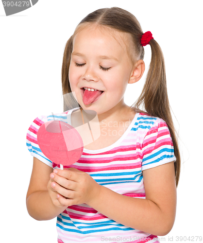 Image of Little girl is going to lick her lollipop