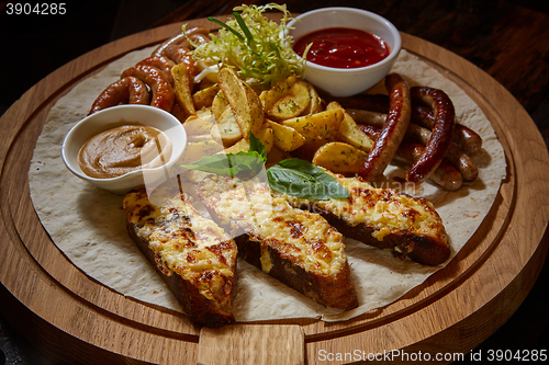 Image of Assorted fried sausages, grilled potatoes, sauce Adjika, Mustard Sauce
