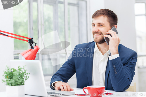 Image of Portrait of businessman talking on phone in office