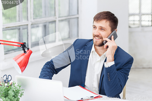 Image of Portrait of businessman talking on phone in office