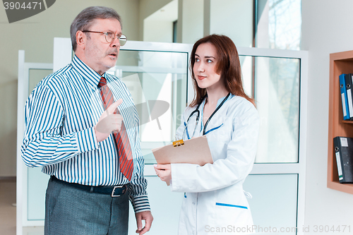 Image of patient listening to his doctor in medical office