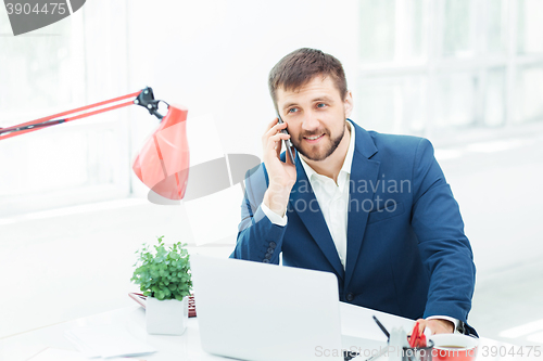 Image of Portrait of businessman talking on phone in office