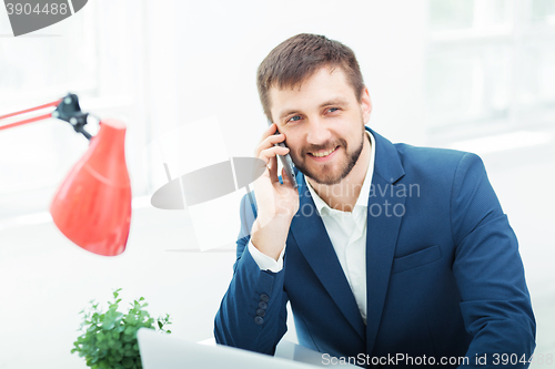 Image of Portrait of businessman talking on phone in office