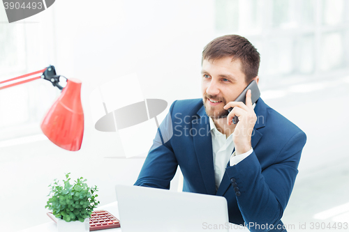 Image of Portrait of businessman talking on phone in office