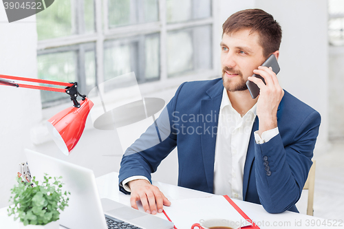 Image of Portrait of businessman talking on phone in office