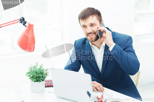 Image of Portrait of businessman talking on phone in office