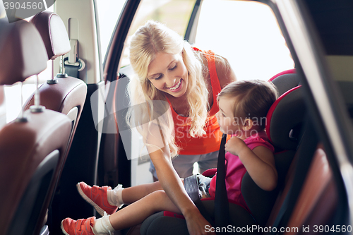 Image of happy mother fastening child with car seat belt