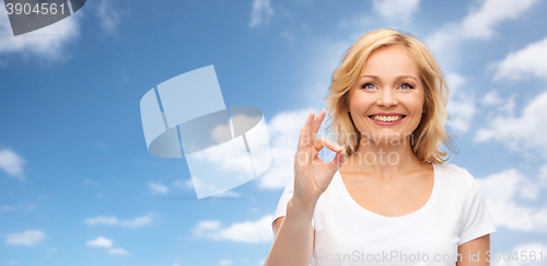 Image of happy woman in white t-shirt showing ok hand sign