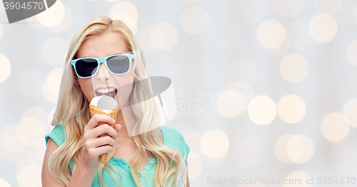 Image of happy young woman in sunglasses eating ice cream