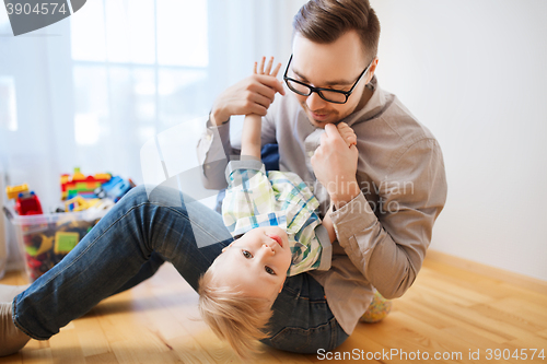 Image of father with son playing and having fun at home