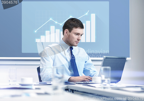 Image of businessman with laptop working in office