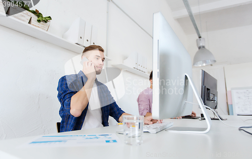 Image of happy creative man calling on cellphone at office