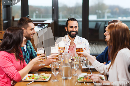 Image of friends dining and drinking beer at restaurant