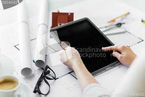 Image of close up of hand with blueprint and tablet pc