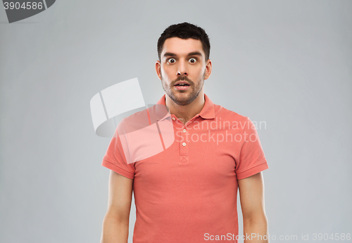 Image of surprised man in polo t-shirt over gray background