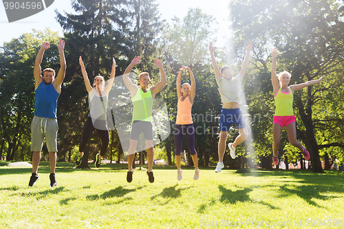 Image of group of happy friends jumping high outdoors