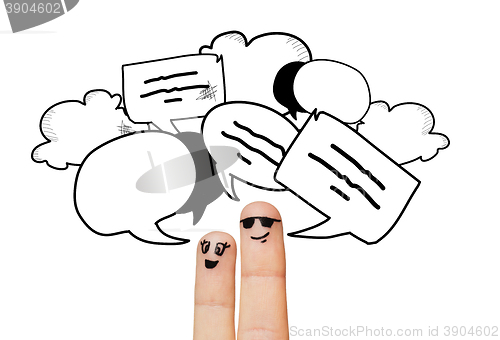 Image of close up of two fingers with communication clouds