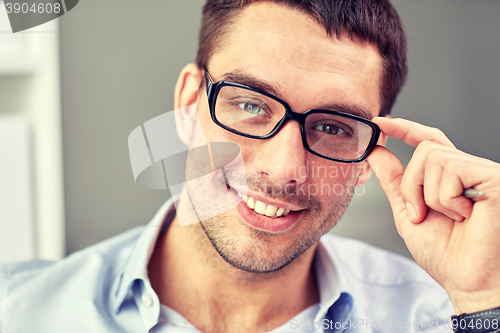 Image of portrait of businessman in eyeglasses at office