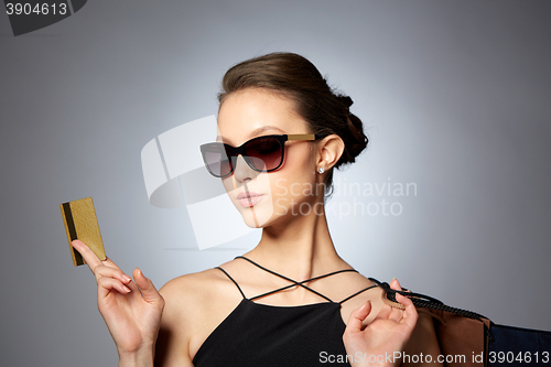 Image of happy woman with credit card and shopping bags