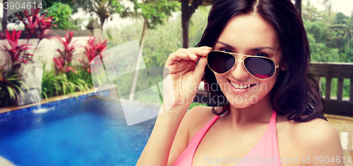 Image of happy woman in sunglasses and swimsuit