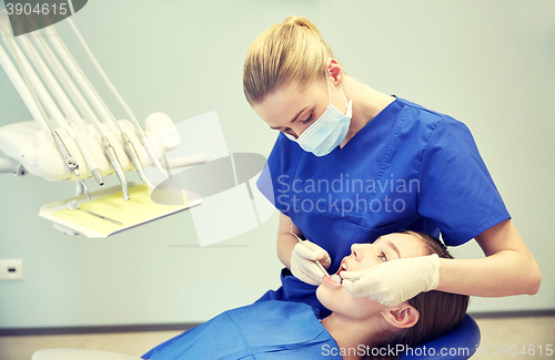 Image of female dentist checking patient girl teeth