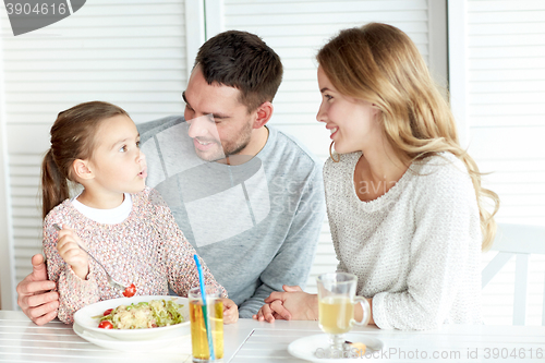 Image of happy family having dinner at restaurant or cafe