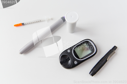 Image of close up of glucometer, insulin pen and syringe