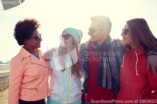 Image of happy teenage friends in shades talking on street