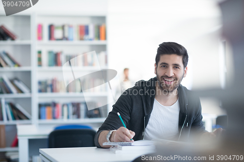 Image of student in school library using laptop for research